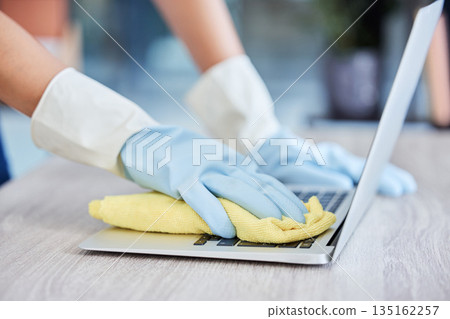 Hands, cleaning laptop keyboard with cloth, wipe away dust and bacteria with disinfectant with hygiene and closeup. Person with gloves clean pc, technology and office maintenance with cleaner service Hands, cleaning laptop keyboard with cloth, wipe away dust and bacteria with disinfectant with hygiene and closeup. Person with gloves clean pc, technology and office maintenance with cleaner service 135162257