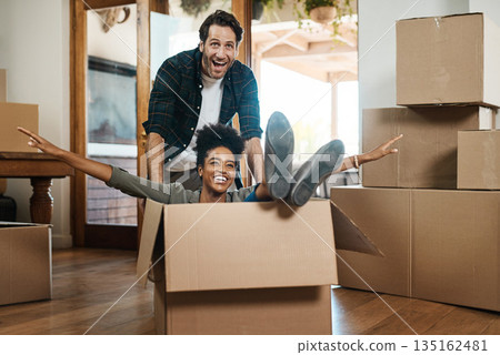 Happy couple, box and real estate in new home or property for renovation and investment together. Excited interracial man, woman and playing in boxes, moving to house or celebration of fun relocation 135162481