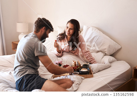 Food, happy couple and eating breakfast in bed, home meal and bonding over Valentines day surprise. Marriage honeymoon, happiness and sweet man, hungry woman or morning people relax in hotel bedroom 135162598
