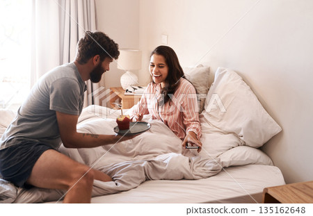 Happy couple, bed and surprise birthday cupcake, morning dessert or celebration food for excited woman. Muffin candle, marriage love and people smile, wow and celebrate special day in home bedroom 135162648