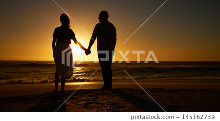 Beach, sunset and a silhouette couple holding hands on vacation or holiday outdoor. Behind man and woman in nature with creative art, mockup space and ocean for love, care and travel or freedom Beach, sunset and a silhouette couple holding hands on vacation or holiday outdoor. Behind man and woman in nature with creative art, mockup space and ocean for love, care and travel or freedom 135162739