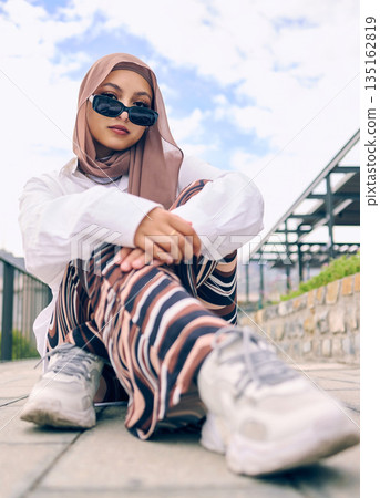Portrait, fashion or hijab with an islam woman outdoor in sunglasses and scarf for contemporary style. Arab, faith or burka with a trendy young muslim person outside in a city wearing modern clothes Portrait, fashion or hijab with an islam woman outdoor in sunglasses and scarf for contemporary style. Arab, faith or burka with a trendy young muslim person outside in a city wearing modern clothes 135162819