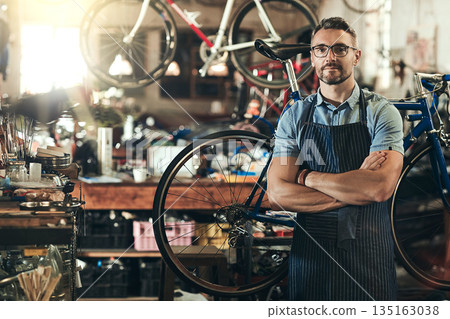 Portrait, serious and repair man in bicycle shop with arms crossed in workshop. Face, bike mechanic and confident male person, professional or mature technician and glasses in store or small business Portrait, serious and repair man in bicycle shop with arms crossed in workshop. Face, bike mechanic and confident male person, professional or mature technician and glasses in store or small business 135163038