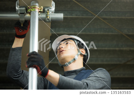 Workers assembling single-tube pipes at a factory site 135163583