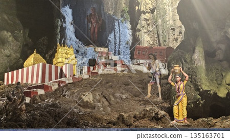 This is cave diorama features golden temples, ritual figures, and natural rock textures, blending Hindu symbolism in Batu Cave inside 135163701