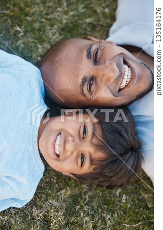 Family, portrait and lying on grass in backyard with father and kid together with love. Face, top view and dad with child on holiday with with parent support and care on a lawn with happy smile Family, portrait and lying on grass in backyard with father and kid together with love. Face, top view and dad with child on holiday with with parent support and care on a lawn with happy smile 135164176