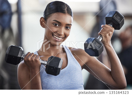 Portrait of woman in gym, dumbbell and smile for weightlifting, power and muscle at sports club. Balance, fitness and female bodybuilder holding weights and training with health goals and happiness. Portrait of woman in gym, dumbbell and smile for weightlifting, power and muscle at sports club. Balance, fitness and female bodybuilder holding weights and training with health goals and happiness. 135164323
