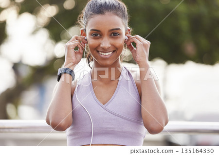 Fitness, portrait of happy woman with headphones in nature on workout break listening to music or podcast. Exercise, training and girl with earphones for radio streaming service while running in park Fitness, portrait of happy woman with headphones in nature on workout break listening to music or podcast. Exercise, training and girl with earphones for radio streaming service while running in park 135164330
