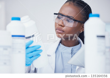Label check tablet, chemical bottle and black woman scientist with mask at pharmaceutical lab. Research, digital reading and science of a female worker with manufacturing job and chemistry inventory 135164356