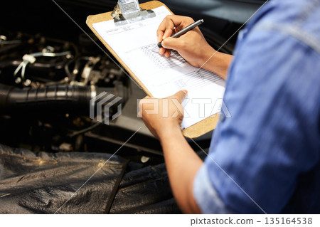 Hands, car mechanic and writing on checklist for service, maintenance and document repair list. Hand, man and engineer with vehicle inspection survey, report and checking engine motor in garage 135164538