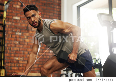Exercise, fitness and man with dumbbell in gym for weightlifting, bodybuilder training and workout. Sports, strong muscles and serious male person lift weight for wellness, healthy body and strength 135164554