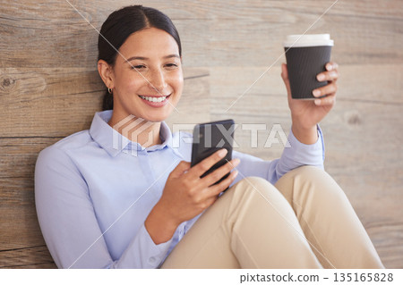 Businesswoman on floor with phone, smile and coffee break browsing internet, social media meme or texting. Happy woman, paper cup and cellphone, relax and checking online post or good news in office. 135165828
