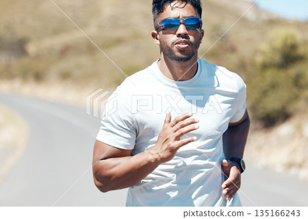 Man, fitness and running in nature for exercise, cardio workout or training outdoors. Fit, active and sporty male person, athlete or runner exercising on mountain asphalt, road or street outside 135166243