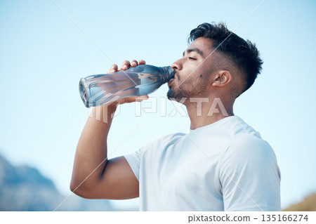 Man, fitness and drinking water in nature exercise, cardio workout or running for sustainability outdoors. Thirsty male person, athlete or runner with drink for hydration, rest or break on mountain 135166274