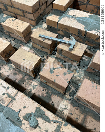 Fresh brickwork of a heating stove bench. The contours of smoke channels are visible. Close-up. Fresh brickwork of a heating stove bench. The contours of smoke channels are visible. Close-up. 135166662