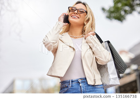 Shopping, phone call and a woman customer in the city carrying bags while looking for a retail deal or sale. Mobile, fashion and consumerism with a young female shopper outdoor in an urban town Shopping, phone call and a woman customer in the city carrying bags while looking for a retail deal or sale. Mobile, fashion and consumerism with a young female shopper outdoor in an urban town 135166738