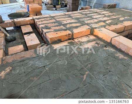 Fresh brickwork of a heating stove bench and firebox area. Close-up. 135166763