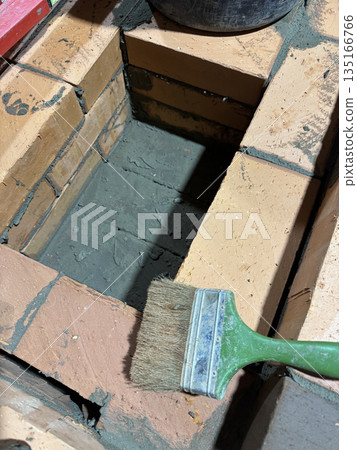 Fresh brickwork of a heating stove ash pit. Close-up. Fresh brickwork of a heating stove ash pit. Close-up. 135166766