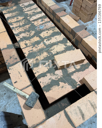 Fresh brickwork of a heating stove bench. Overlap of the benchs smoke channels. Fresh brickwork of a heating stove bench. Overlap of the benchs smoke channels. 135166769