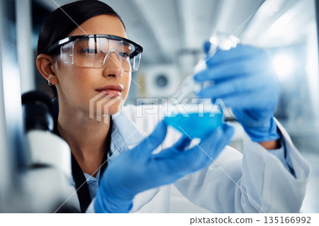 Woman, scientist and study chemical liquid, glass beaker and science chemistry experiment in lab. Female doctor with goggles, gloves and analysis of fluid, scientific innovation and medical research 135166992