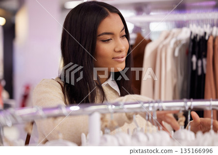 Shopping, fashion and woman with clothes in store for sale, discount and bargain for style. Retail boutique, mall and female person browse clothing on rack for purchase choice, decision and search 135166996