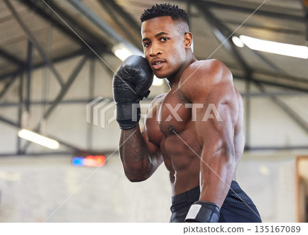 African man, boxing and punching in portrait for fitness, focus or training at gym for growth, goal and competition. African guy, boxer and gloves for exercise, wellness and martial arts for sports 135167089