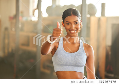 Gym, portrait or Indian woman with thumbs up in fitness training with positive mindset or motivation. Encouragement, support or happy personal trainer in workout with like hand sign or thumb up 135167476