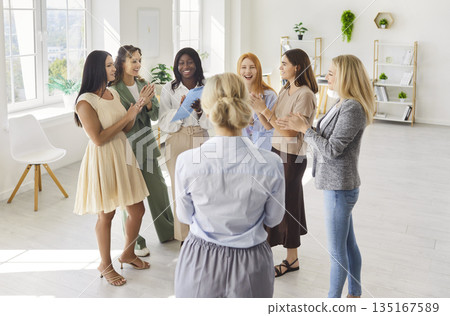 Cheerful women team applauding at group meeting during leadership training Cheerful women team applauding at group meeting during leadership training 135167589