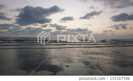Gentle waves washing ashore during a beautiful sunset at the beach Gentle waves washing ashore during a beautiful sunset at the beach 135167596