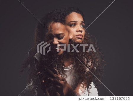 Depression, mental health and woman in studio with stress, identity crisis or bipolar disorder. Horror, psycho and female person with trauma or anxiety browsing on a phone by a dark black background. Depression, mental health and woman in studio with stress, identity crisis or bipolar disorder. Horror, psycho and female person with trauma or anxiety browsing on a phone by a dark black background. 135167635