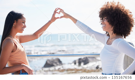 Friends, heart and hands with women at beach for summer, happy and teamwork. Support, freedom and love with people and holding shape in outdoors for collaboration, faith and community gesture Friends, heart and hands with women at beach for summer, happy and teamwork. Support, freedom and love with people and holding shape in outdoors for collaboration, faith and community gesture 135167656