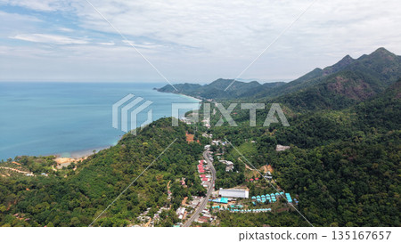 Aerial view of tioman island showing tropical rainforest, mountains, road and coastline Aerial view of tioman island showing tropical rainforest, mountains, road and coastline 135167657