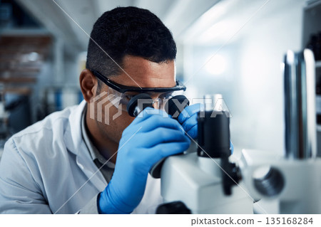 Man, scientist and microscope in forensic science research, discovery or data analysis at lab. Male person or medical professional in scientific results for cure, virus or vaccine in laboratory 135168284