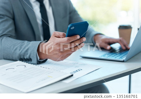 Hands of man with laptop, phone and desk at startup checking email, social media and search on internet at business. Online report, networking and businessman in office typing or reading on cellphone 135168701