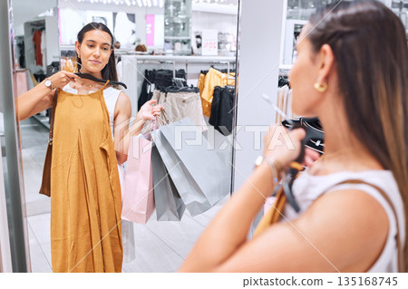 Shopping, fashion and a woman in boutique mirror at mall for clothes sale or discount deal. Female person or happy customer in retail store with a paper bag, luxury brand and style choice or decision Shopping, fashion and a woman in boutique mirror at mall for clothes sale or discount deal. Female person or happy customer in retail store with a paper bag, luxury brand and style choice or decision 135168745