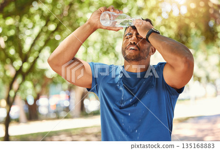 Fitness, outdoor and a man pouring water on face after exercise, training or running at a park. Tired Indian male athlete in nature for workout, run and break or cooling down with a splash in summer Fitness, outdoor and a man pouring water on face after exercise, training or running at a park. Tired Indian male athlete in nature for workout, run and break or cooling down with a splash in summer 135168883