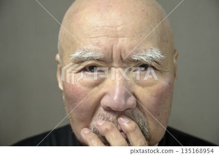 Close-up of an elderly man's troubled face 135168954