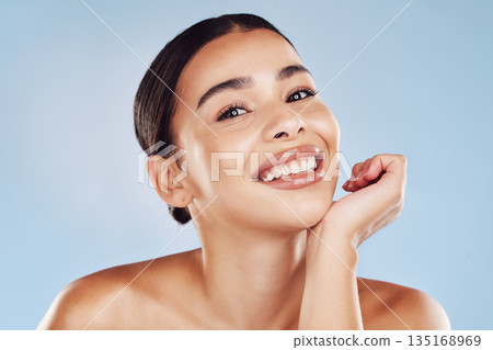 Portrait, skincare and woman with cosmetics, smile and dermatology against blue studio background. Face, female person or model with salon treatment, luxury and grooming with foundation and aesthetic 135168969