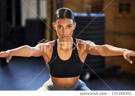 Portrait, fitness or woman doing squats at gym in exercise, workout or leg strength training for wellness. Powerful, female athlete or focused girl exercising legs for strong glutes or bodybuilding 135169301