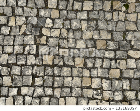 Cobbled pavement with stone pattern. Grey textured road and sidewalk surface in old city square. 135169357