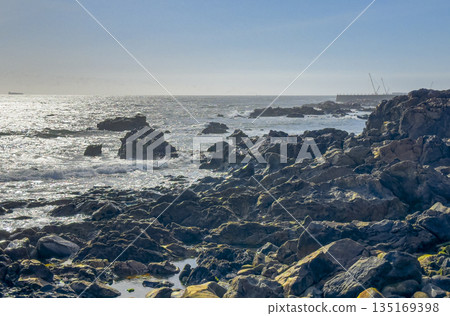 Rock on ocean coast. Scenic seascape with blue water waves, beach, rocky shoreline and horizon, Rock on ocean coast. Scenic seascape with blue water waves, beach, rocky shoreline and horizon, 135169398