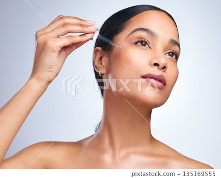 Beauty serum, woman cosmetics and skincare with dermatology and face cleaning. Wellness, hyaluronic acid and young female model with skin glow product and treatment with care and dropper in studio 135169555