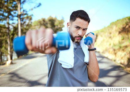 Man, dumbbell and punches in nature fitness for exercise, workout or training in the outdoors. Portrait of fit, active and sporty male person punching with weights in healthy outdoor cardio endurance Man, dumbbell and punches in nature fitness for exercise, workout or training in the outdoors. Portrait of fit, active and sporty male person punching with weights in healthy outdoor cardio endurance 135169573