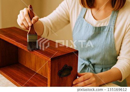 一個人正在給木盒塗棕色清漆，這是他的一個DIY項目。 135169612