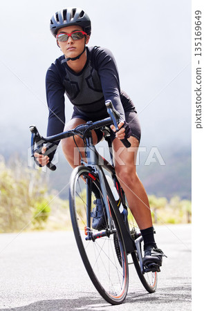 Fitness, woman and cyclist training, wellness and workout with exercise, wellness and endurance. Female person, biker and athlete in the street, cycling and biking with speed, energy and adventure 135169649