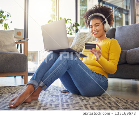 Headphones, credit card and woman on laptop for home online shopping, ecommerce or fintech payment on floor. Relax, music and happy african person on internet banking, audio subscription and computer 135169678