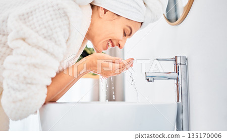 Water splash, skincare and happy woman washing her face in a bathroom for beauty, hygiene and wellness. Facial, cleaning and female with drops for dermatology and cleansing treatment in her home 135170006