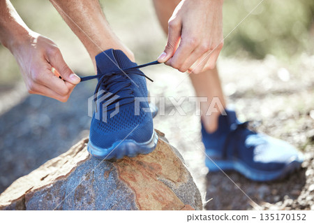 Man, hands and tie shoes for running, fitness or getting ready for workout, hiking or walk in nature. Hand of male person, hiker or runner tying shoe for trekking, run or cardio exercise outdoors 135170152