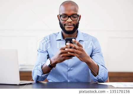 Black man, phone and desk in office with search on internet for networking, email or social media. Online research, digital marketing and businessman with glasses, cellphone and laptop at start up. Black man, phone and desk in office with search on internet for networking, email or social media. Online research, digital marketing and businessman with glasses, cellphone and laptop at start up. 135170156