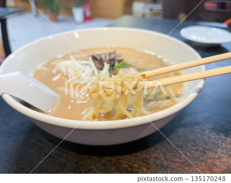 Creamy tonkotsu ramen, a famous noodle dish from the Kyushu region of Japan, topped with bean sprouts, wood ear mushrooms, and roasted pork. 135170248